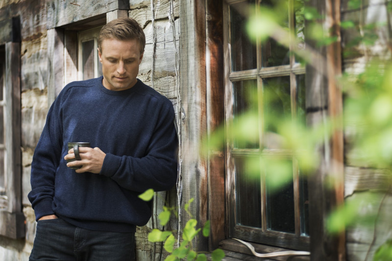A  man with a blue jumper at home on his property.